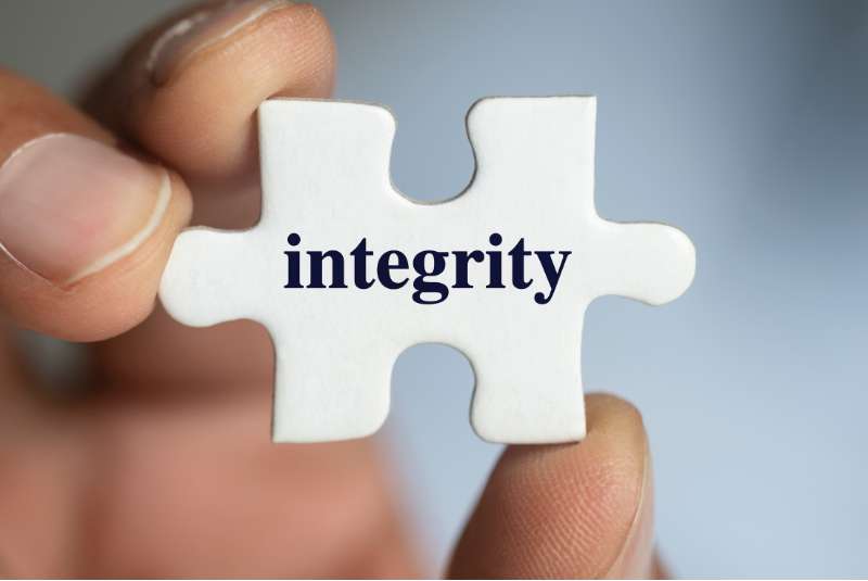 hand holding a puzzle with integrity written on it